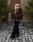 کت زنانه Flygo از خز مصنوعی (Faux Fur) – سبک پُرزدار و نرم (Fluffy/Shaggy)، با آستین بلند، یقه لبه‌دار (Lapel)، مناسب برای زمستان، مدل کوتاه (Short Coat/Parka). 1574